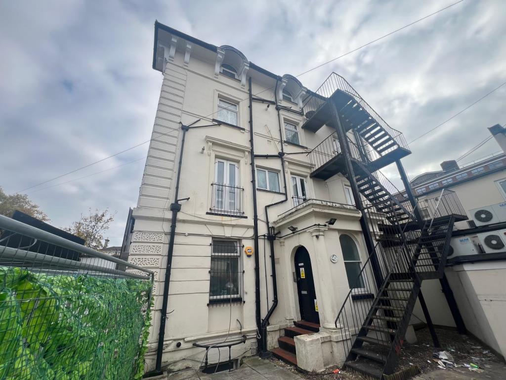 Lot: 10 - FREEHOLD MIXED COMMERCIAL AND RESIDENTIAL INVESTMENT - Side elevation of building showing entrance to flats